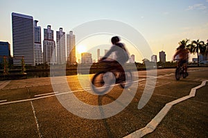 Man riding bicycle on cycling lane in city public park at morning