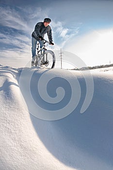 Man riding on a bicycle in a deep snow, winter extreme