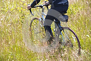 Man riding bicycle on field with tall grass