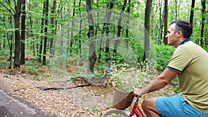 a man riding a bicycle in the forest, in the summer