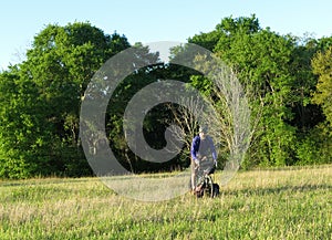 Man riding bicycle in green meadow