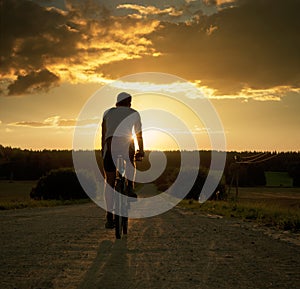 Man Riding a Bicycle at Sunset