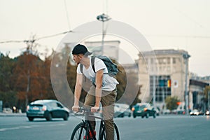 Man riding bicycle in urban city holding hands on handlebar