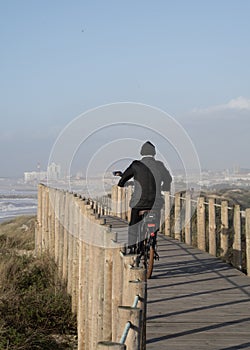 Man riding electric bike on wooden path at sunset