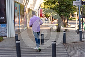 Man riding an electric scooter in the sidewalk