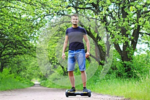 Man riding an electrical scooter outdoors - hover board, smart balance wheel, gyro scooter, hyroscooter, personal Eco transport photo