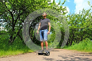 Man riding an electrical scooter outdoors - hover board, smart balance wheel, gyro scooter, hyroscooter, personal Eco transport photo