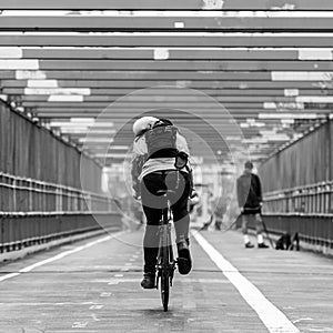 Man riding his bike in the cycling lane on Williamsburg Bridge, Brooklyn, New York City.