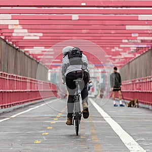 Man riding his bike in the cycling lane on Williamsburg Bridge, Brooklyn, New York City.