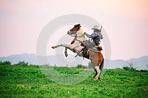 Man riding horse in field against sunset and mountain