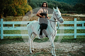 Man riding a horse. Hunky cowboy rides horse. Country life concept. photo