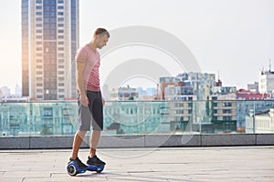 Man riding hoverboard, city background.