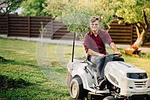 man riding a lawnmower and doing landscaping works