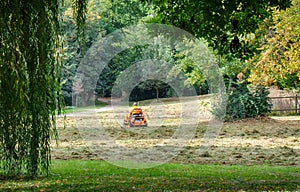 Man riding on a lawnmower tractor in a park