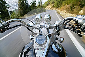 Man riding motorcycle on an empty country road.