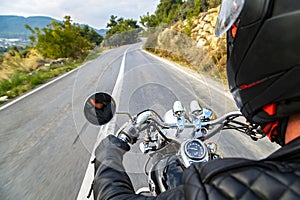 Man riding motorcycle on an empty country road.