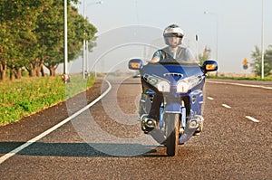 Man riding a motorcycle on an open road