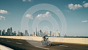 Man Riding Motorcycle in Panama City With Skyline in Background