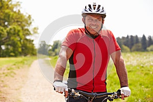 Man Riding Mountain Bike Along Path In Countryside