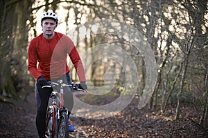 Man Riding Mountain Bike Through Woodlands photo