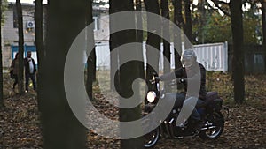 Man Riding old custom cafe-racer Motorcycle on forest Country Road at sunset