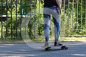 A man is riding a skateboard in the park. Legs close up. The photo