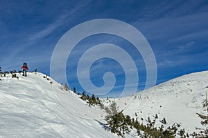 A man riding a snowboard down a snow covered slope