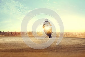 Man riding sport motorcycle on dirt road against urban building