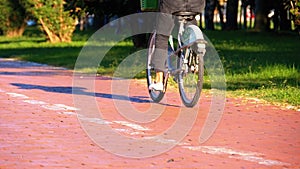 Man Riding an Three-wheeled Electric Scooter on Bike Path in the Park. Slow Motion