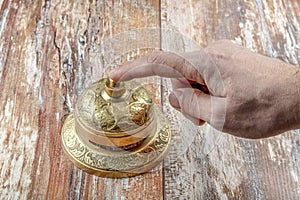 Man ringing in service bell on reception table, closeup