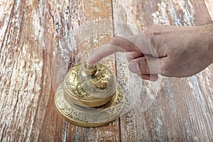 Man ringing in service bell on reception table, closeup