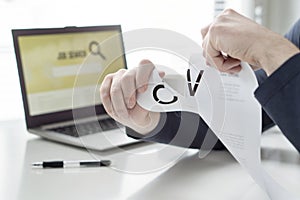 Man ripping his CV and curriculum vitae. Person having problems finding work or writing his job application paper. photo