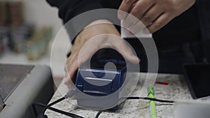 A man rips a receipt from a payment terminal in a store after making a purchase.