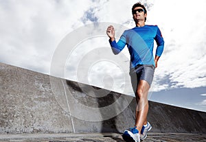 Man, road and active for running outdoors, sports and athlete for performance training in city. Male person, full body