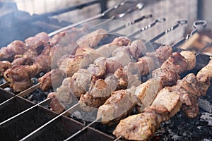 a man roasts meat on a fire. Close-up of hands and barbecue.