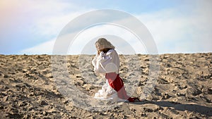 Man in robe repenting for sins, praying to God in desert, pangs of conscience