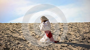 Man in robe repenting for sins, praying to God in desert, pangs of conscience photo