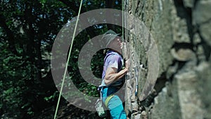 Man rock climber climbs on a granite cliff, gripping hold but falling