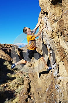 Man rock climbing a boulder