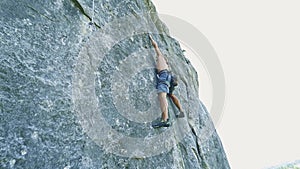 Man rock climbing on tough sport route, rock climber makes a hard move and falls.
