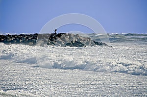 Man on Rock Jetty During Storm