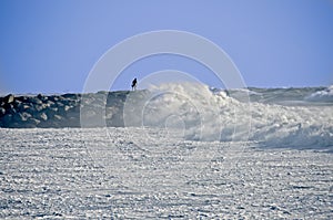 Man on Rock Jetty During Storm