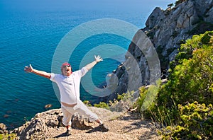 Man on rock and shouts against sea