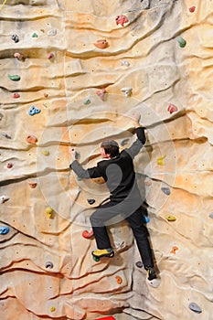 Man on rock wall in sport center