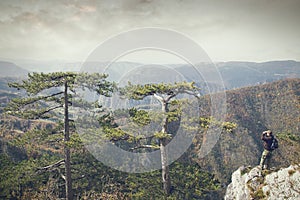 Man on a rock watching the environment binoculars