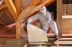 Man with rockwool panel installing insulation layer photo