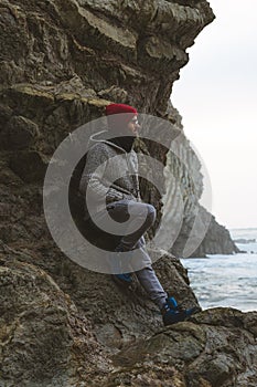 A man on the rocky shore looking out to sea