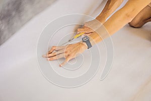 man and a roll of insulating cloth to install a laminate wooden floor