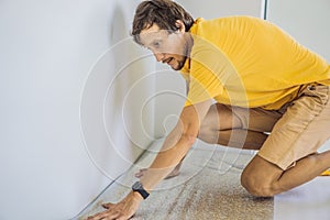 man and a roll of insulating cloth to install a laminate wooden floor