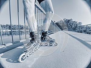 Man roller skater in speed hard shell skates. Man try trick on the pathway